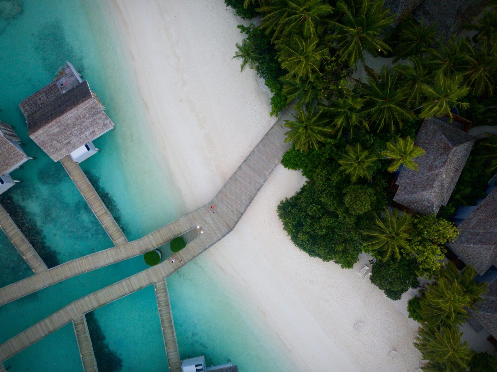 A stunning aerial view of a tropical beach resort with turquoise waters and lush greenery.